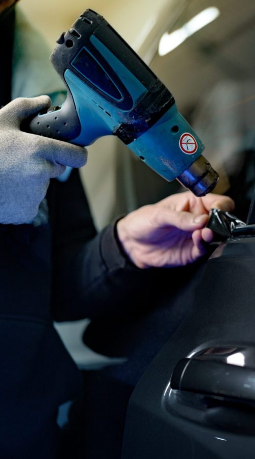 Close up of male car service worker applying nano coating on a car